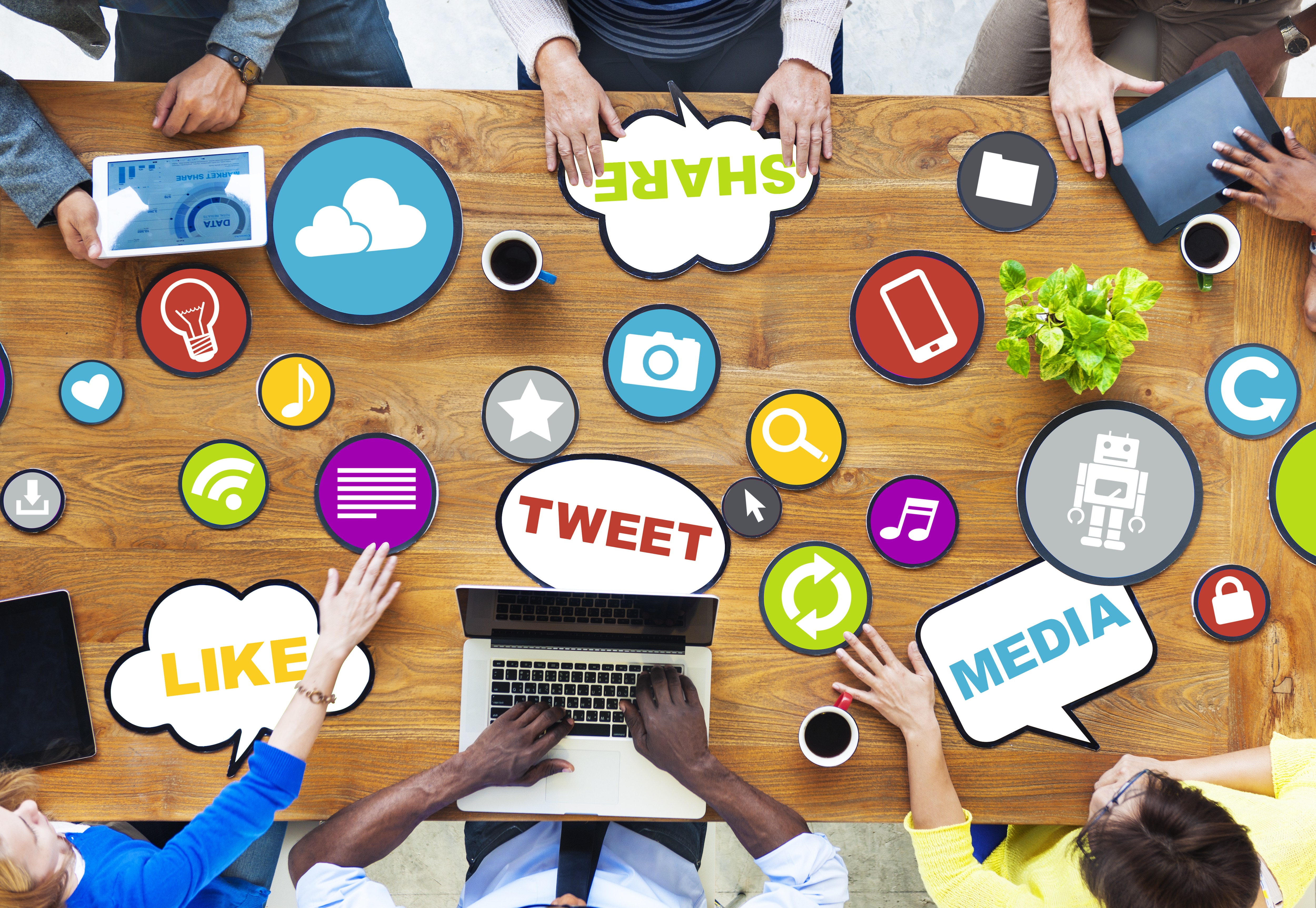 People around a table, with buzz words like tweet as graphics on the table.